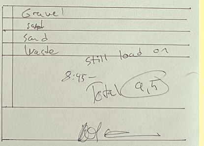 A photograph of a real handwritten truck ticket: gravel, sand and waste written into the material rows, and the hours totalled by hand to 9.5 and circled.